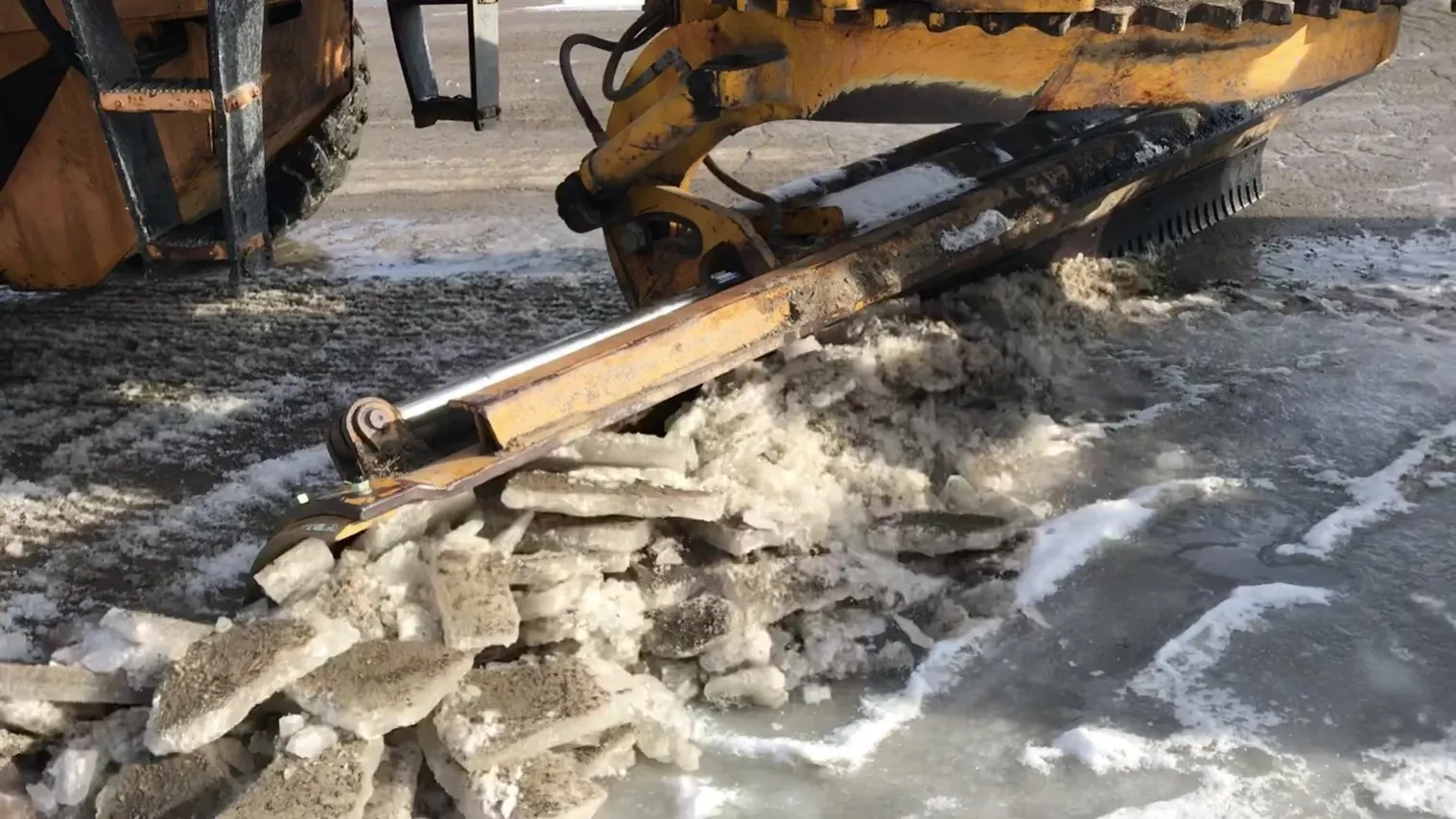 An image of an ice blade chopping up ice from a roadway.